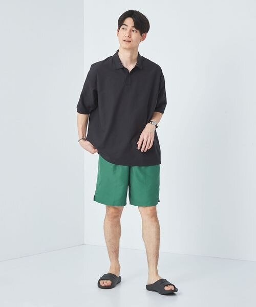 緑のパンツ×黒いシャツのコーデ