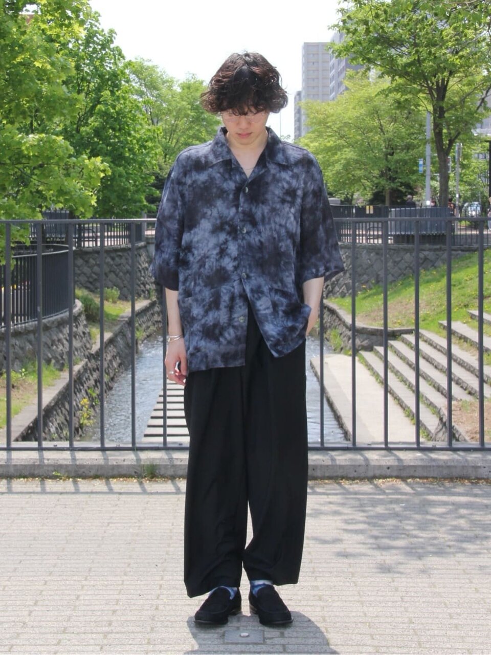オープンカラーシャツとイージーパンツを着た男性