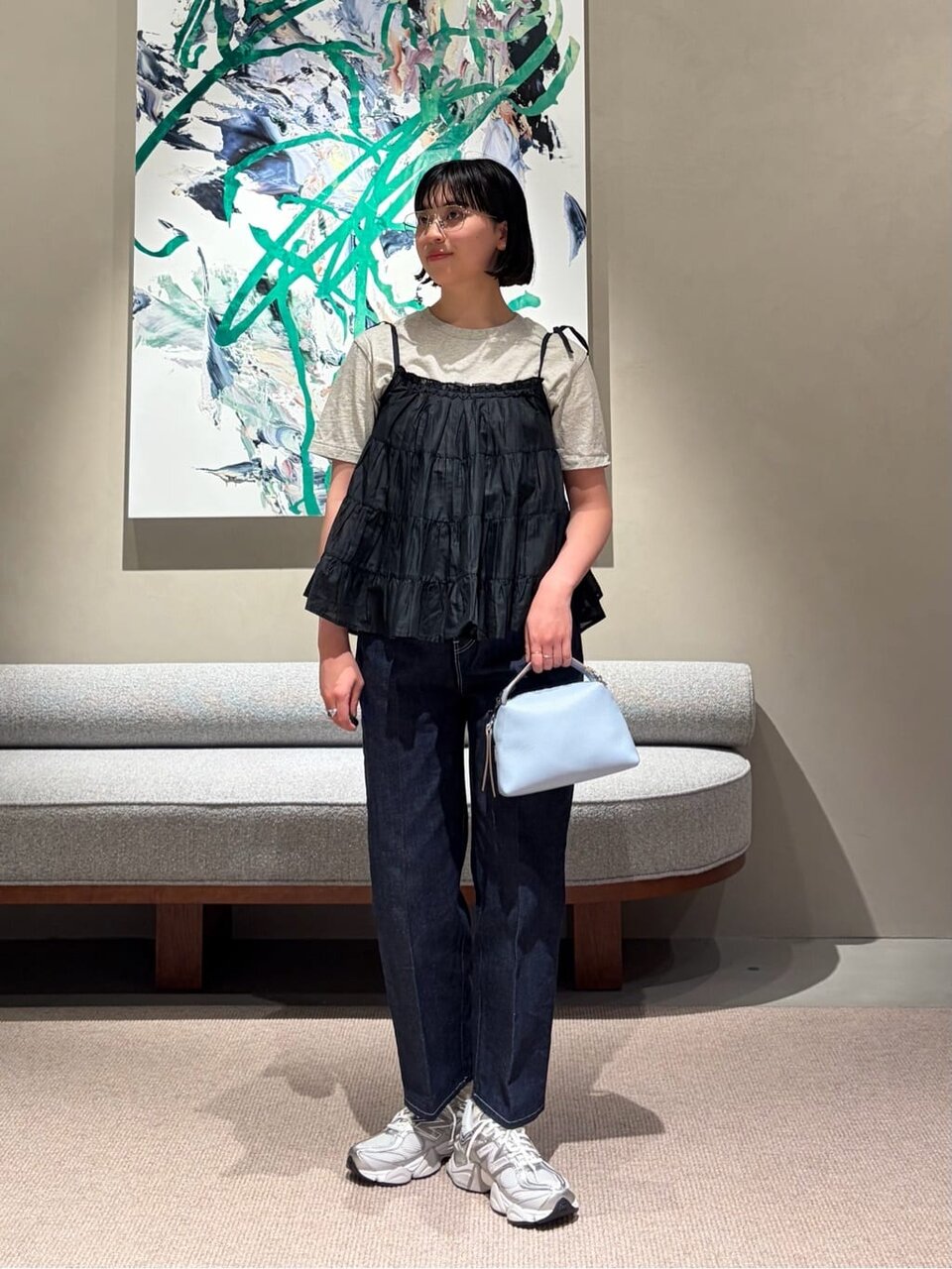 黒のキャミソールとデニムパンツを着た女性
