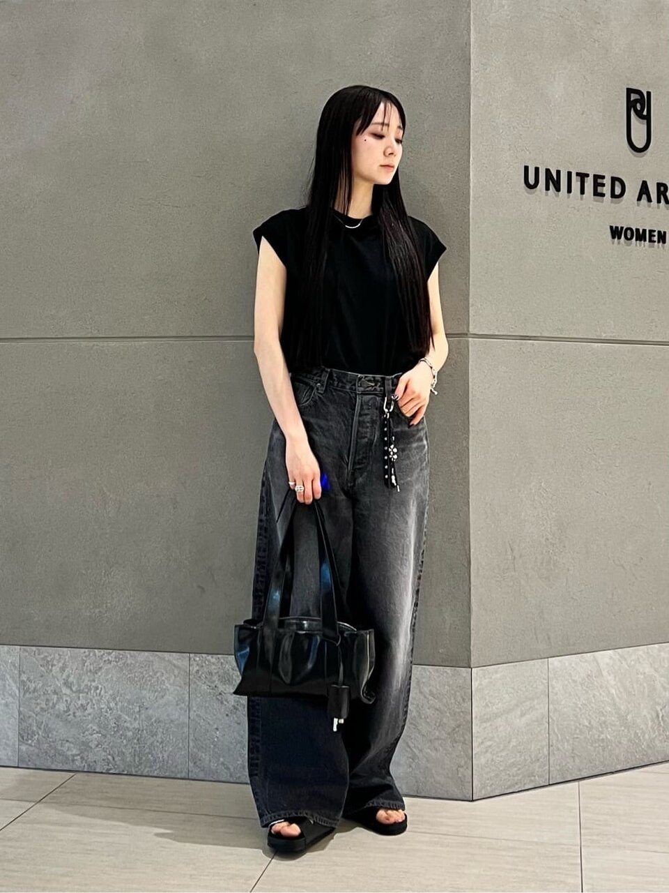 黒のノースリーブとデニムパンツを着た女性
