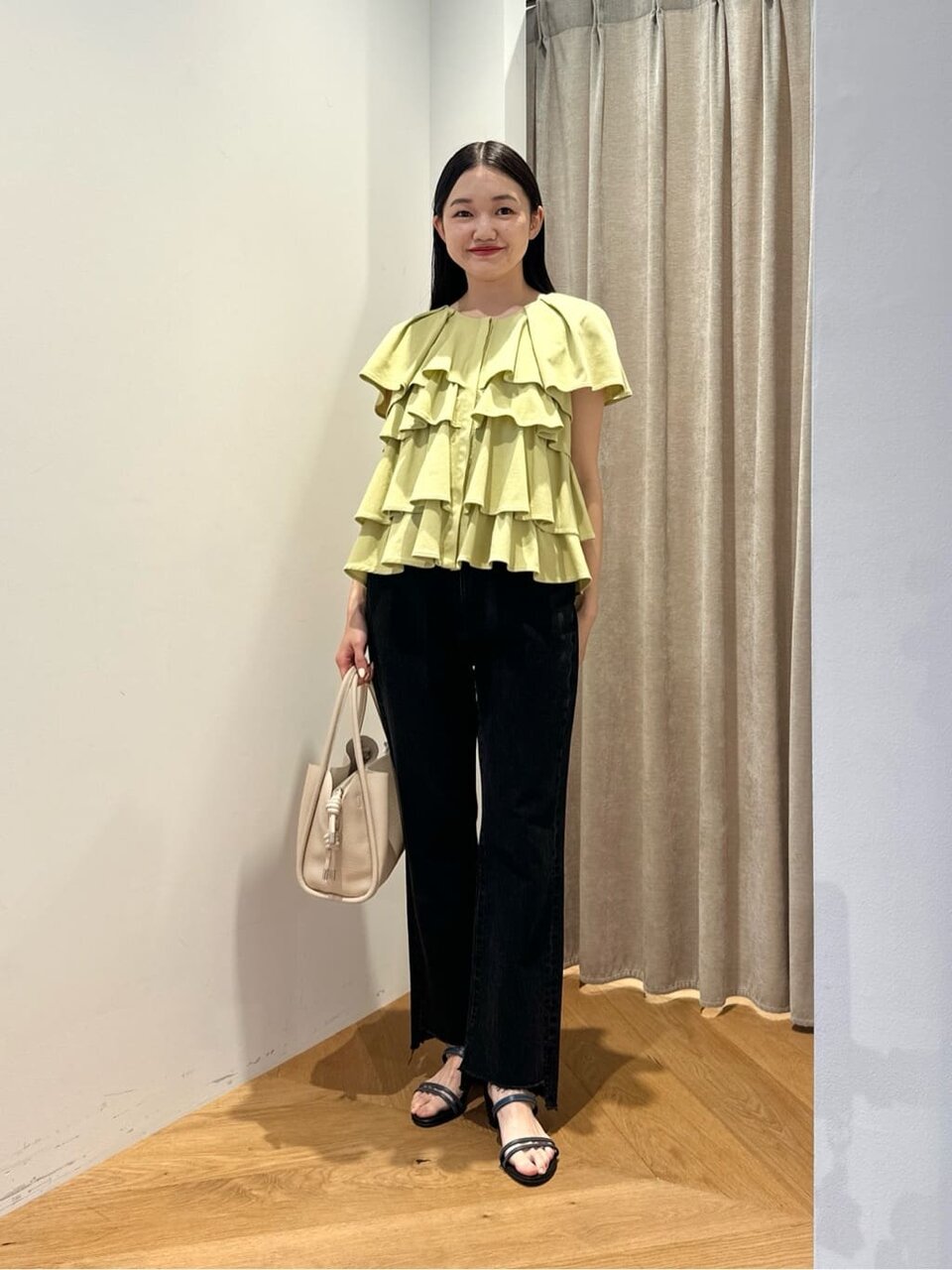 フリルカットソーとデニムパンツを着た女性