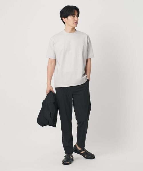 寒暖差にあわせられる上着を手にもつ男性