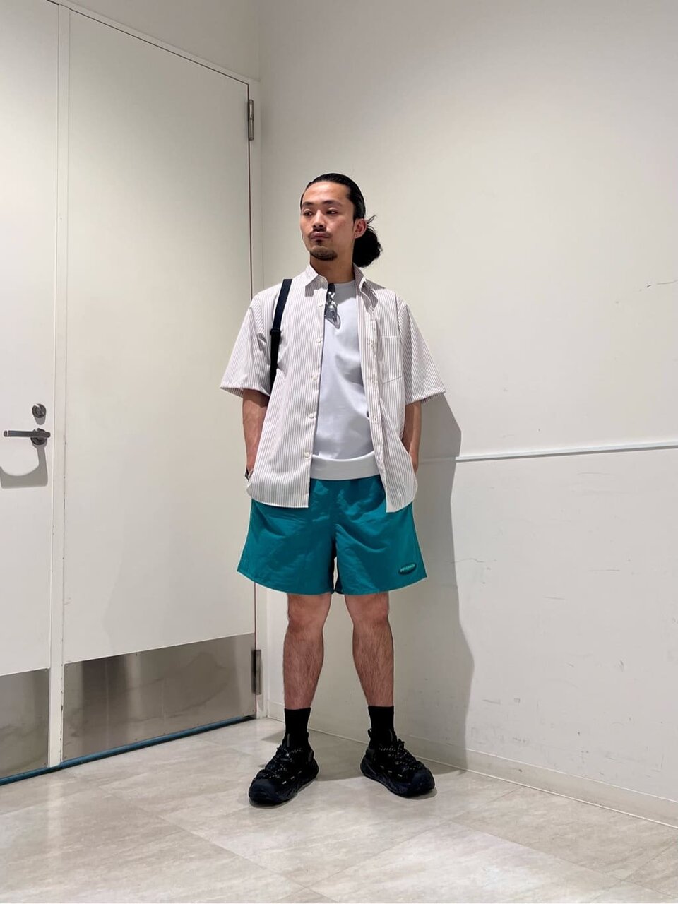 ベージュのシャツ×緑のショートパンツのコーデ