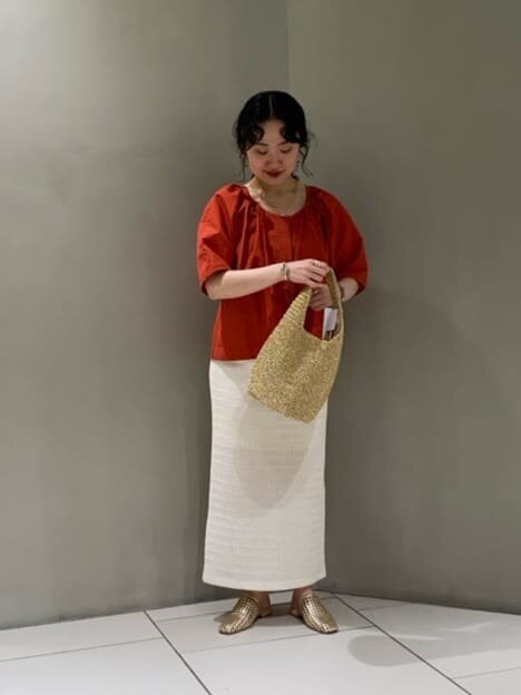 オレンジ色のブラウスを着た女性