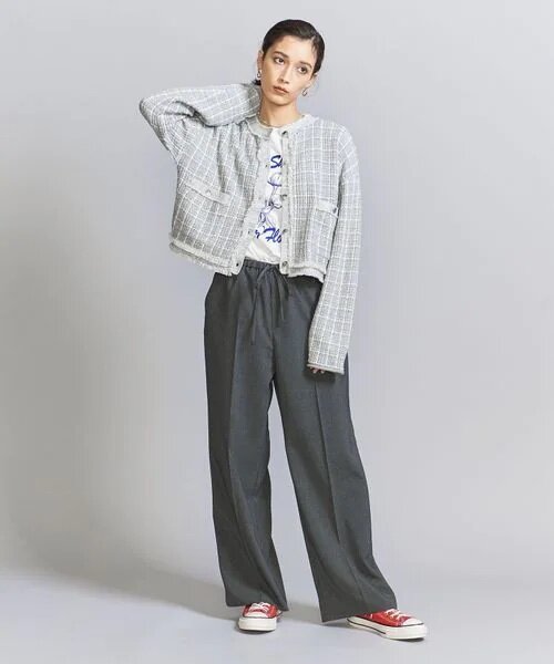 ワイドパンツにショート丈カーディガンを着た女性