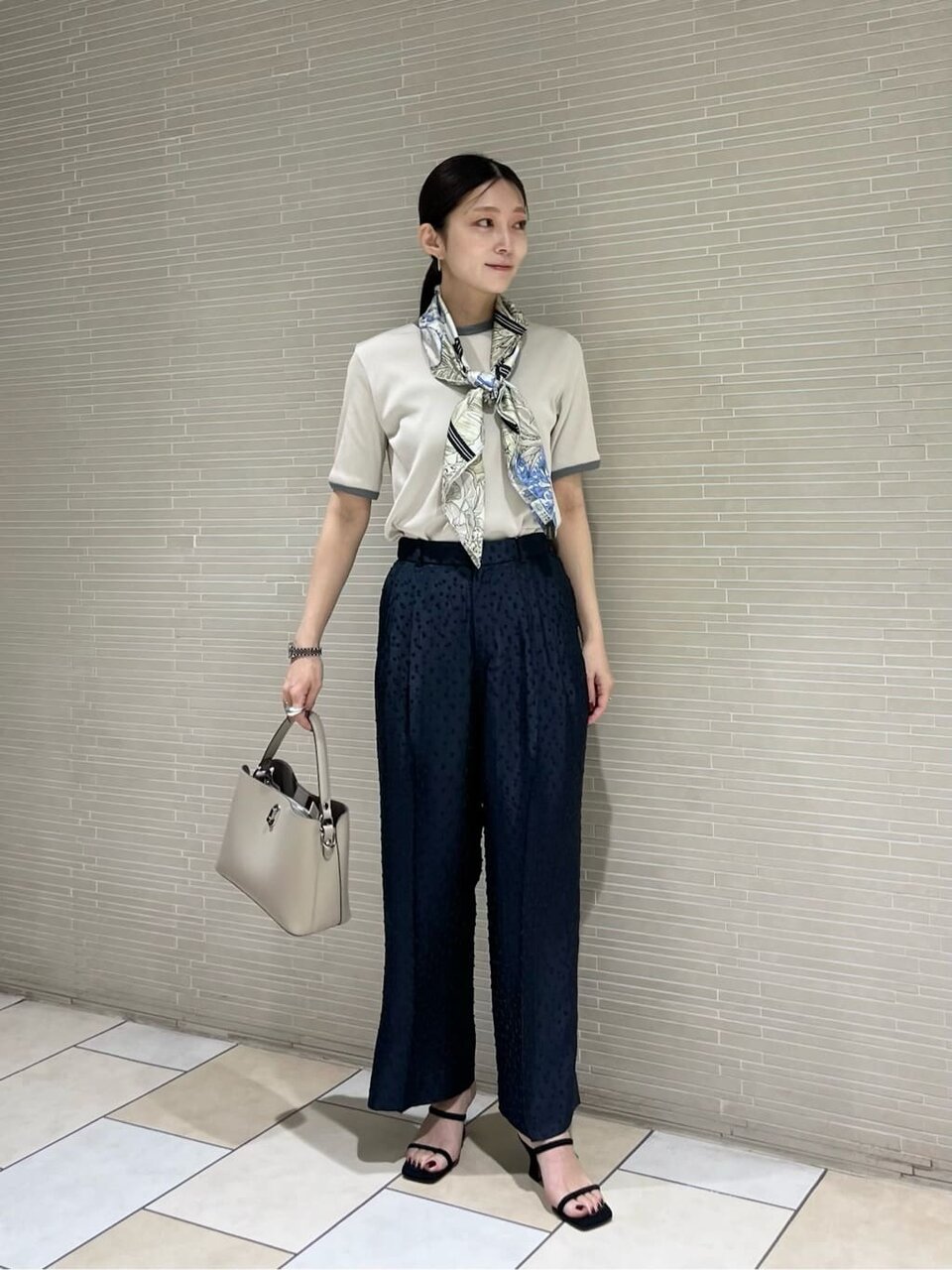 パイピングTシャツとスラックスを着た女性