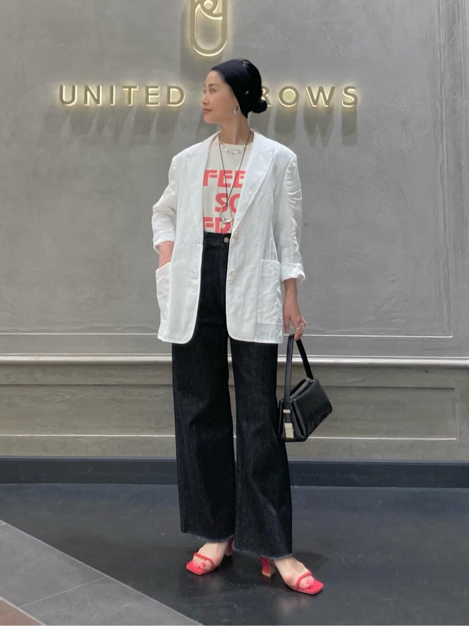 白いジャケットとロゴTシャツを着た女性