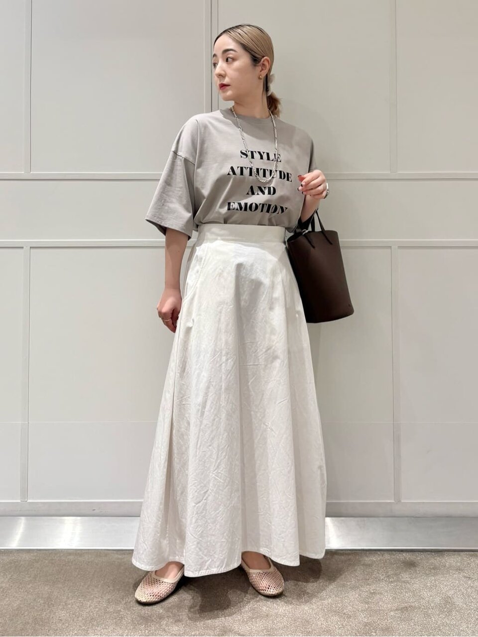グレーのTシャツと白いスカートを着た女性
