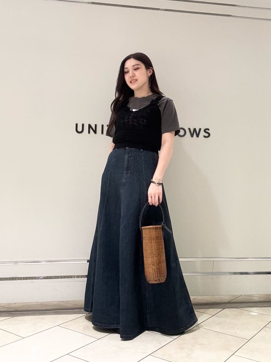 Tシャツとスカートにニットベストを着た女性