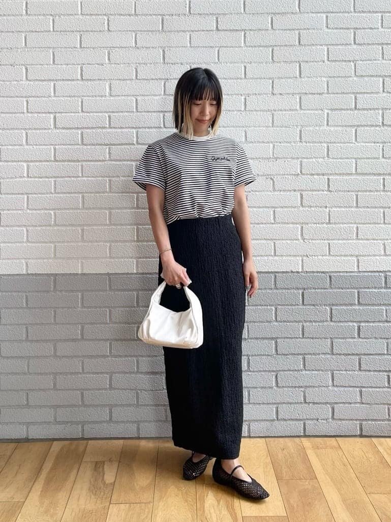 ボーダーTシャツと黒いタイトスカートを着た女性