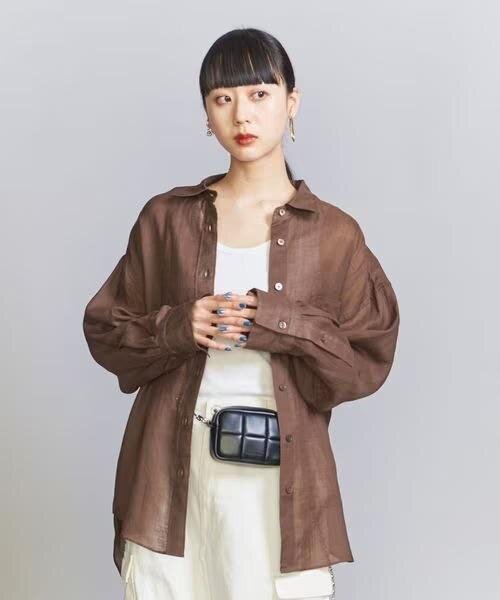ブラウンの麻のシャツを着た女性