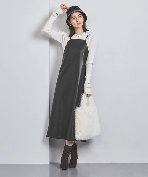 黒のフェイクレザーワンピースを着た女性