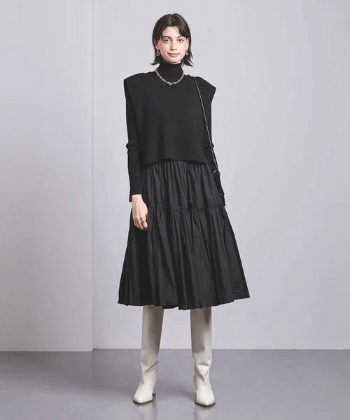 黒いワンピースに白いブーツをあわせた女性