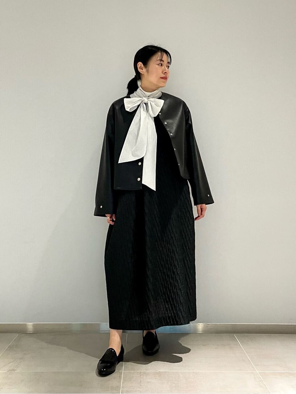 白のボウタイブラウス×黒のレザーライクブルゾン