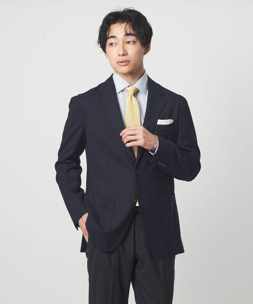 ジャケパンにネクタイを締めた男性