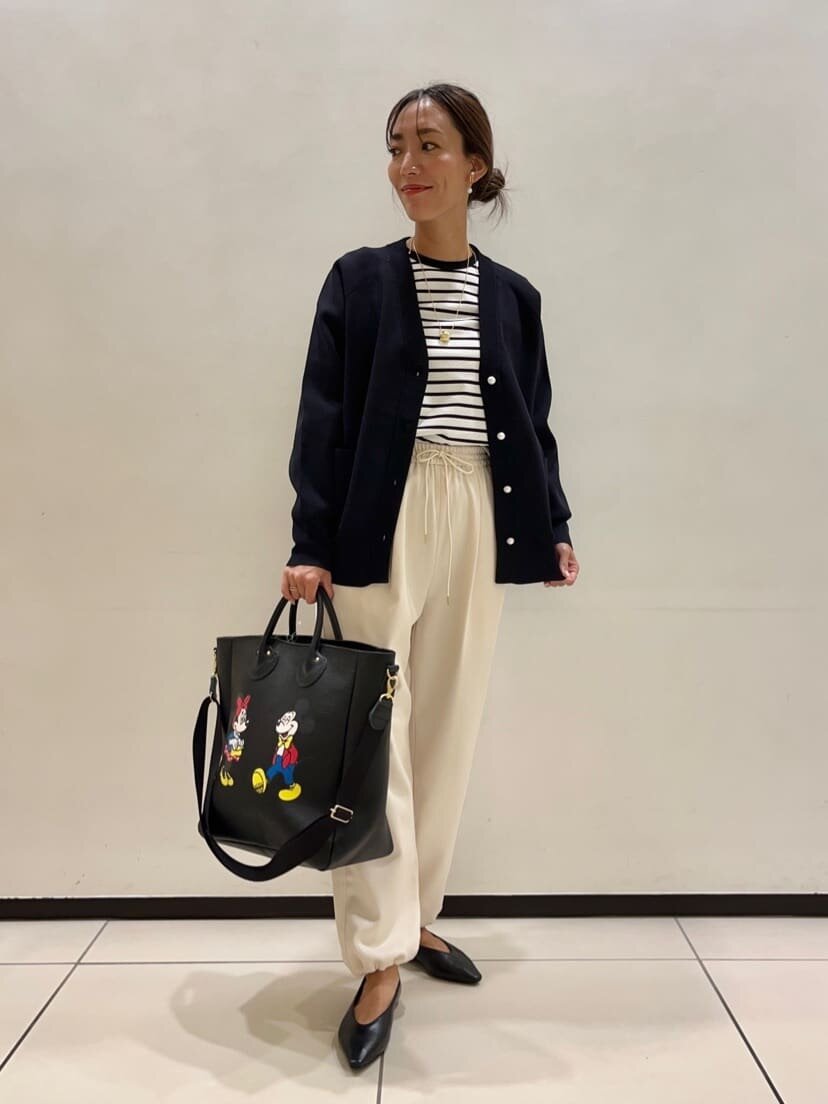 カーディガンとホワイトパンツを着用した女性
