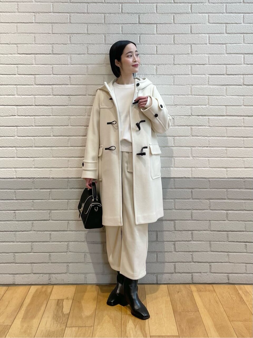 白いダッフルコートを着た女性