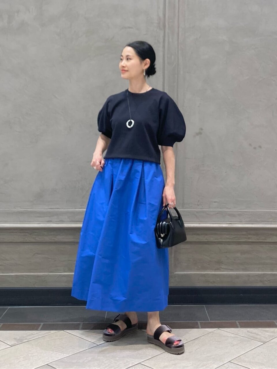 コバルトブルーのスカートをはいた女性