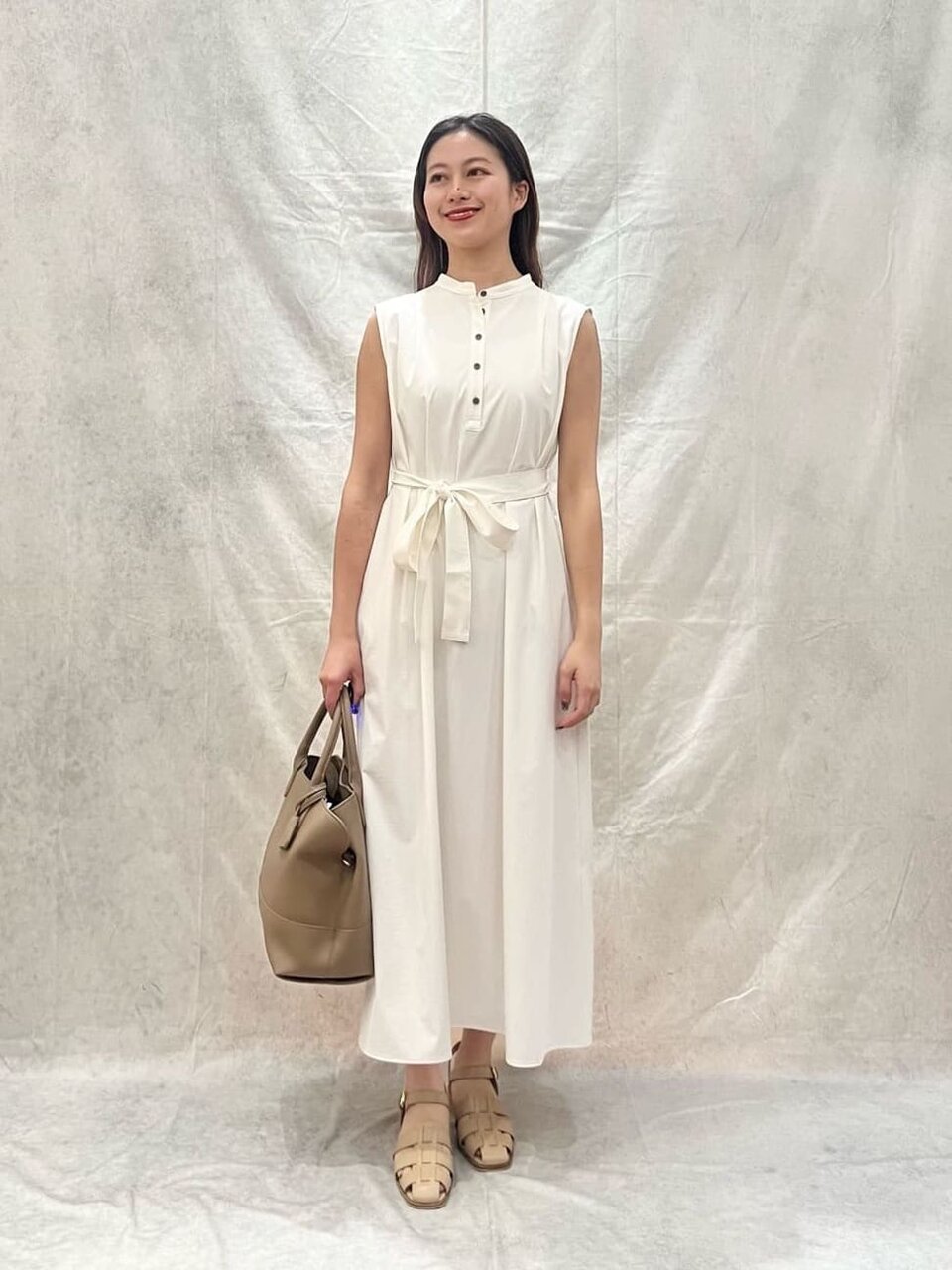 白いワンピースを着たサンダルの女性