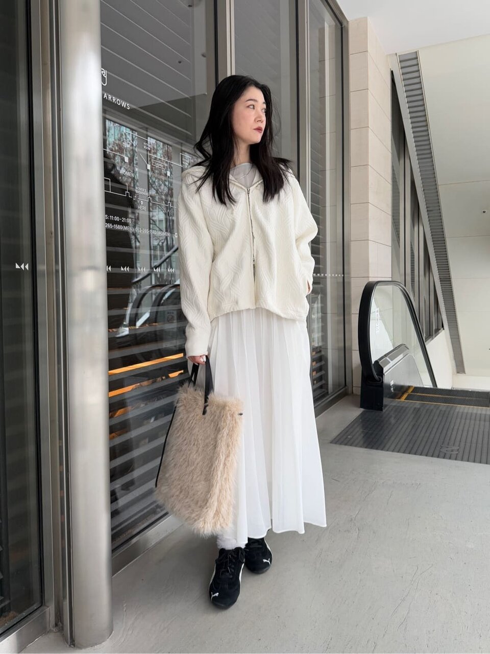 白いスウェットパーカーとスカートを着た女性