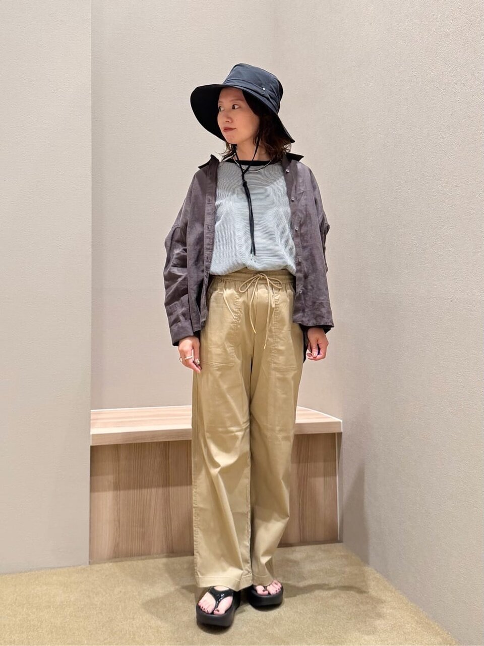 Tシャツパンツにプリムハットを被った女性