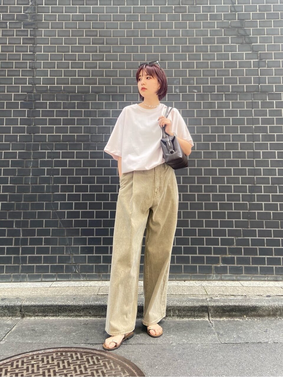 ピンクのTシャツとワイドパンツを着た女性