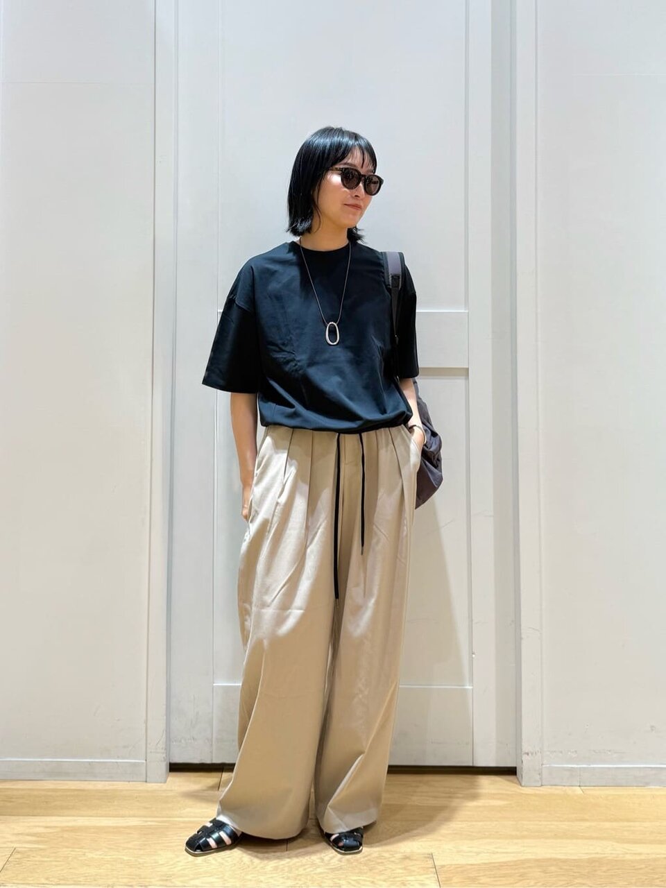 黒のTシャツとスラックスを着た女性