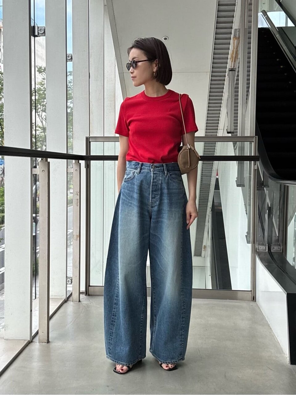 赤いTシャツとデニムパンツを着た女性