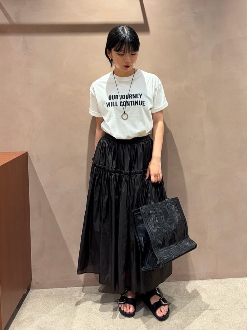 ロゴTシャツとギャザーフレアスカートを着た女性