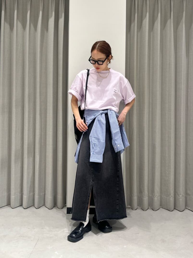 ライトピンクのTシャツとデニムスカートを着た女性
