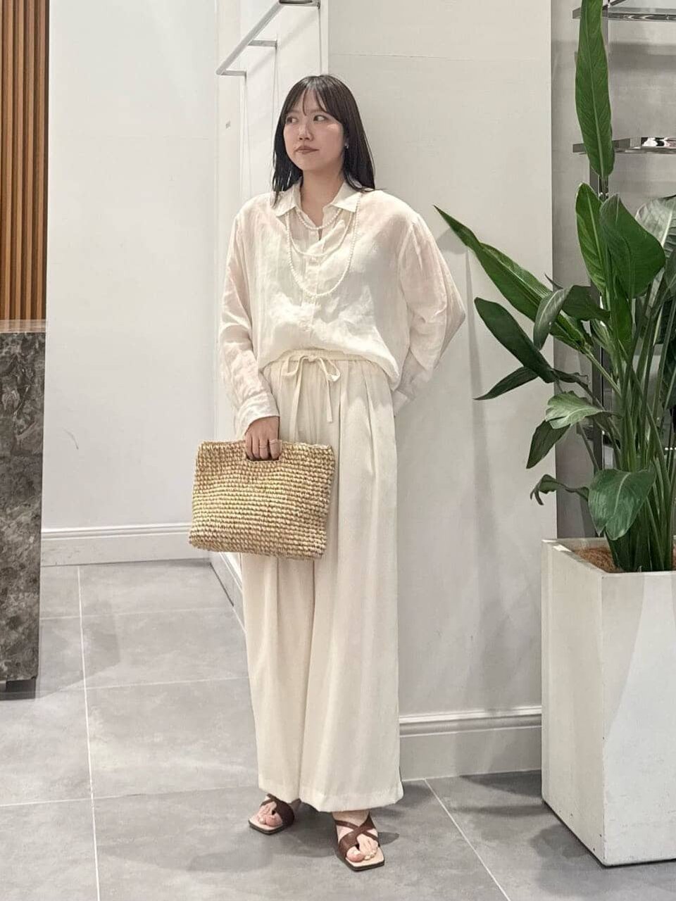 麻のシャツとイージーパンツを着た女性