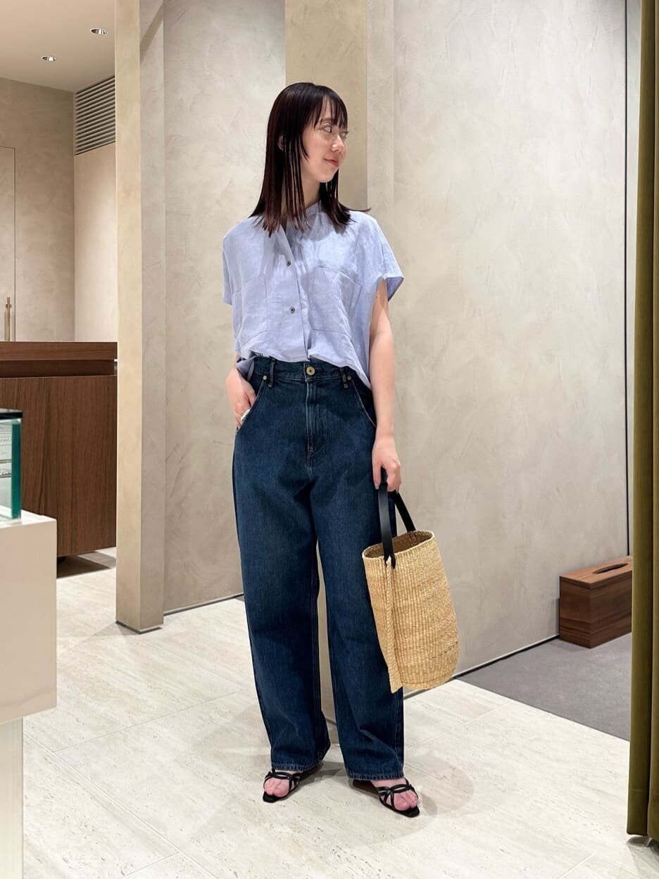 麻のシャツとデニムパンツを着た女性