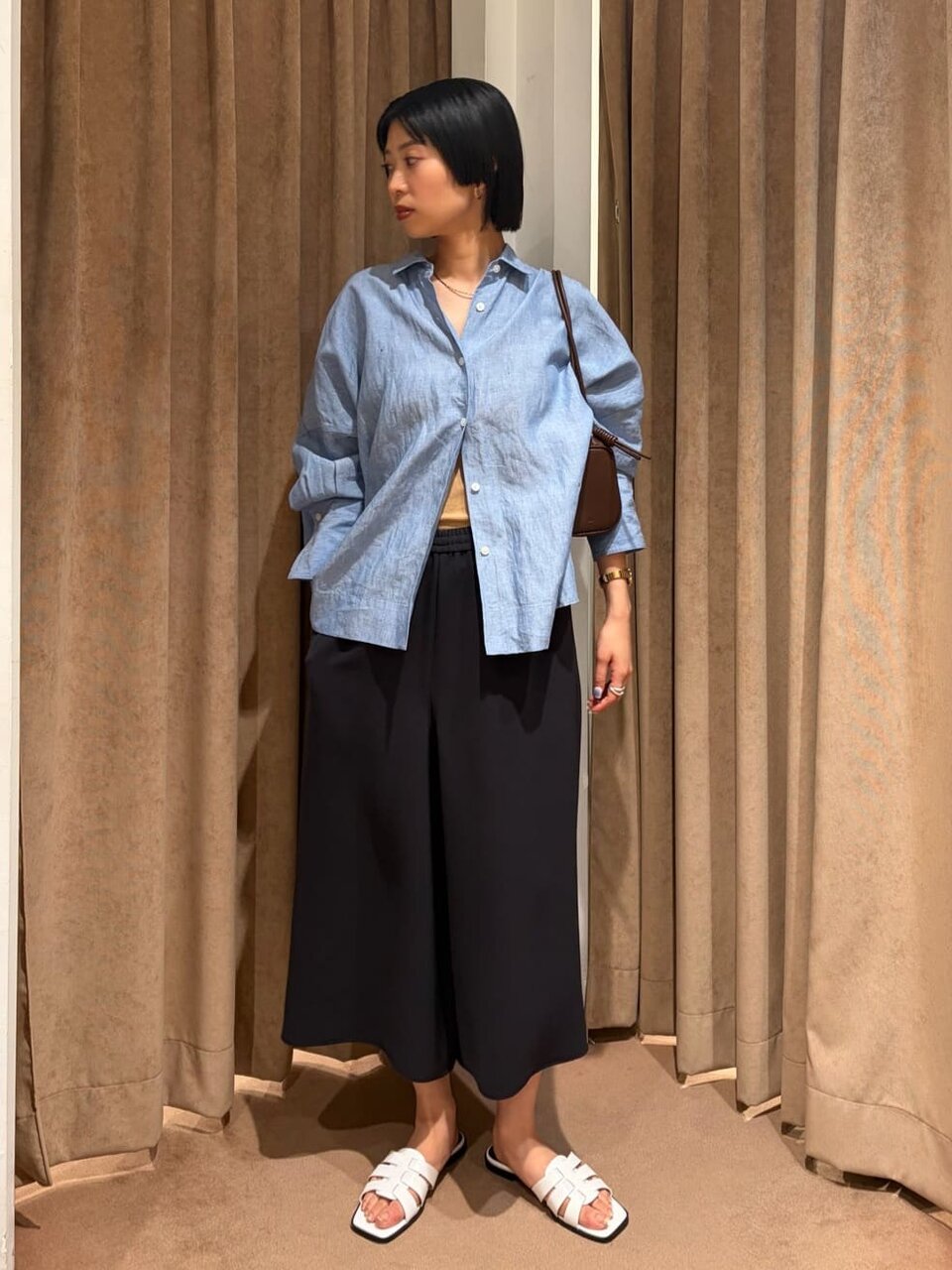 麻のシャツとキュロットパンツを着た女性