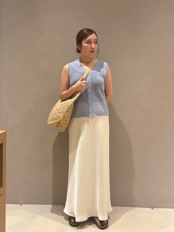 ニットベストとマーメイドスカートを着た女性