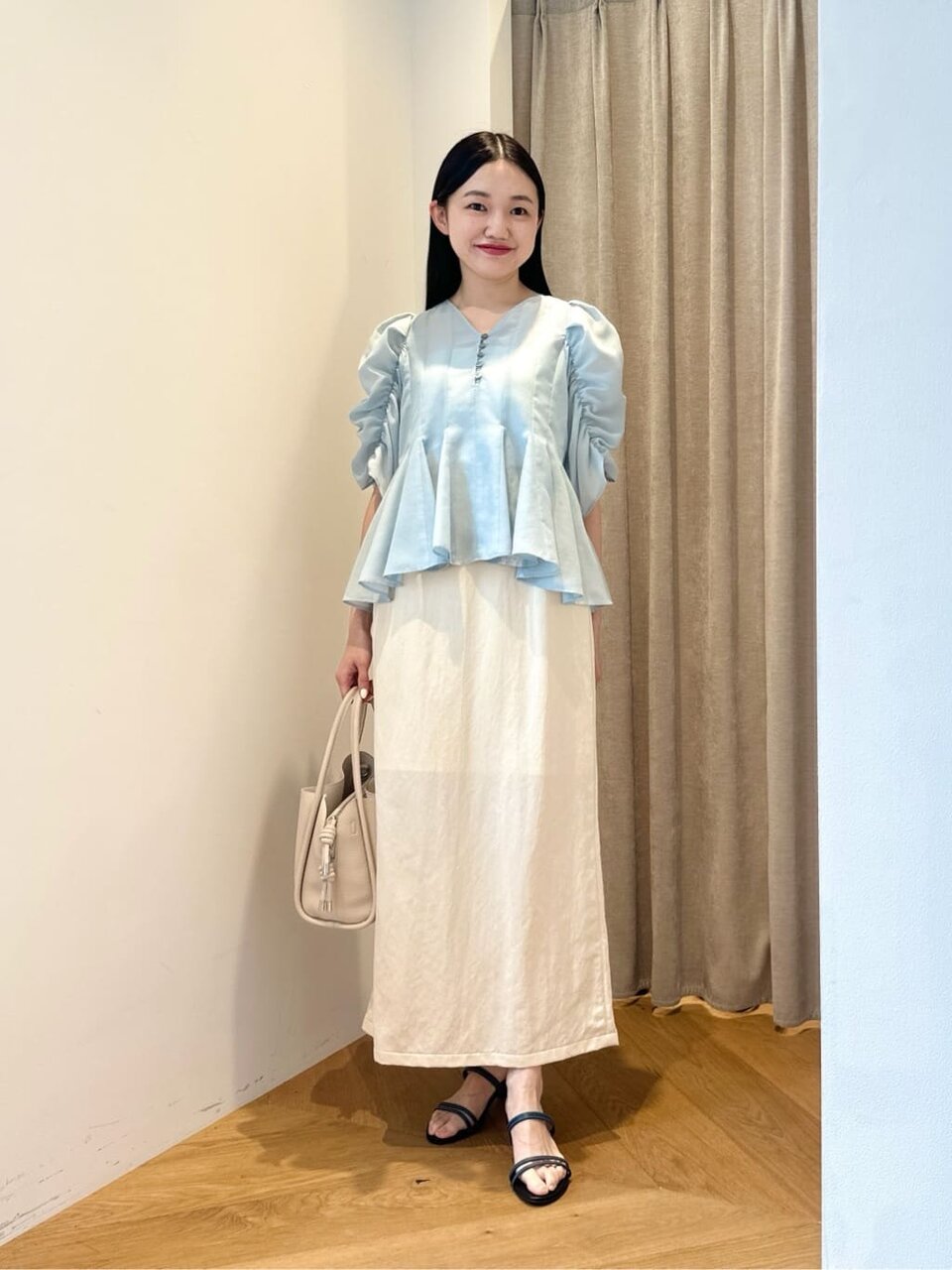 ギャザースリーブブラウスとマーメイドスカートを着た女性
