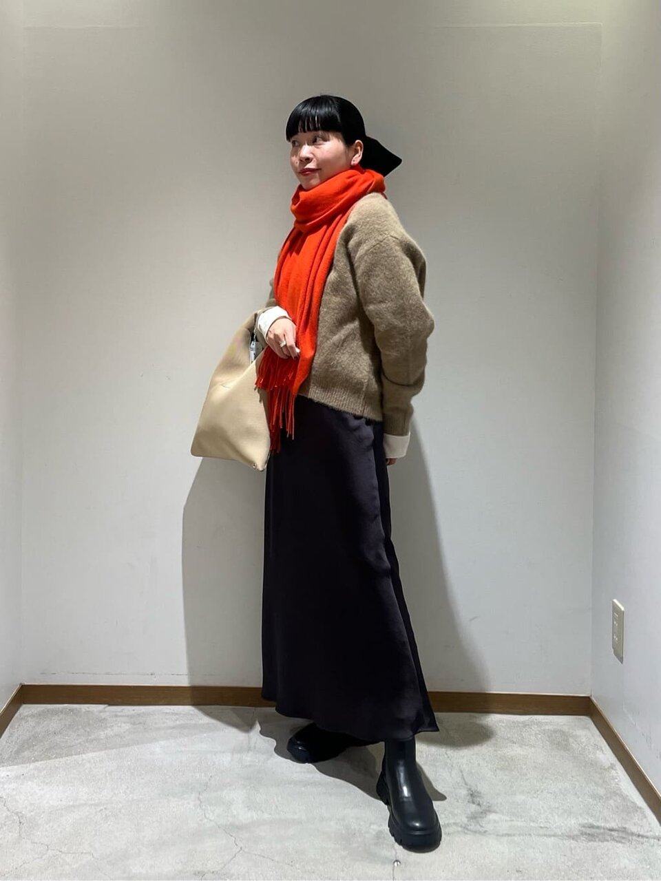 Vネックニットとマーメイドスカートを着た女性
