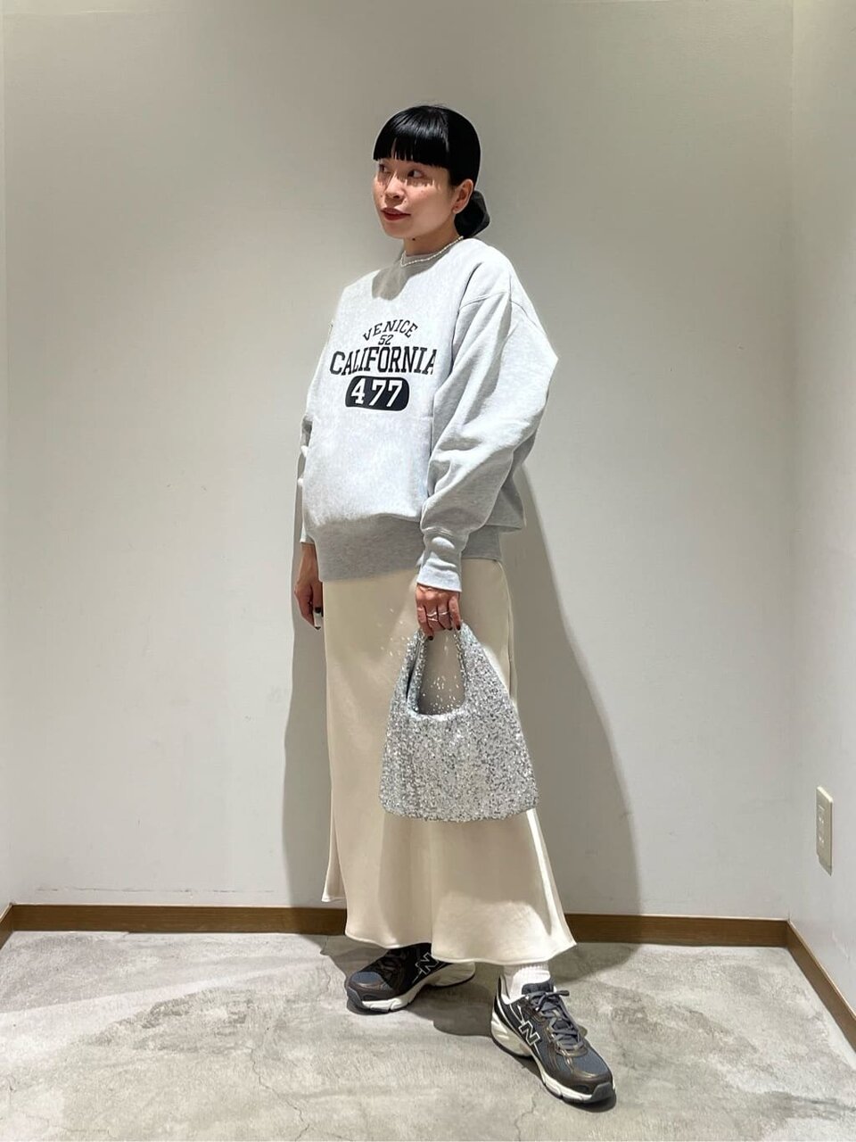 スウェットとマーメイドスカートを着た女性