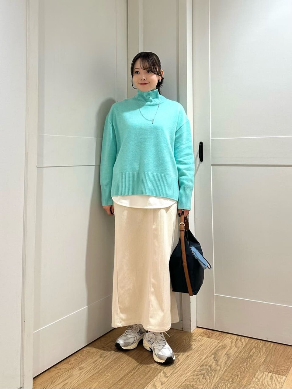 ハイネックニットとマーメイドスカートを着た女性