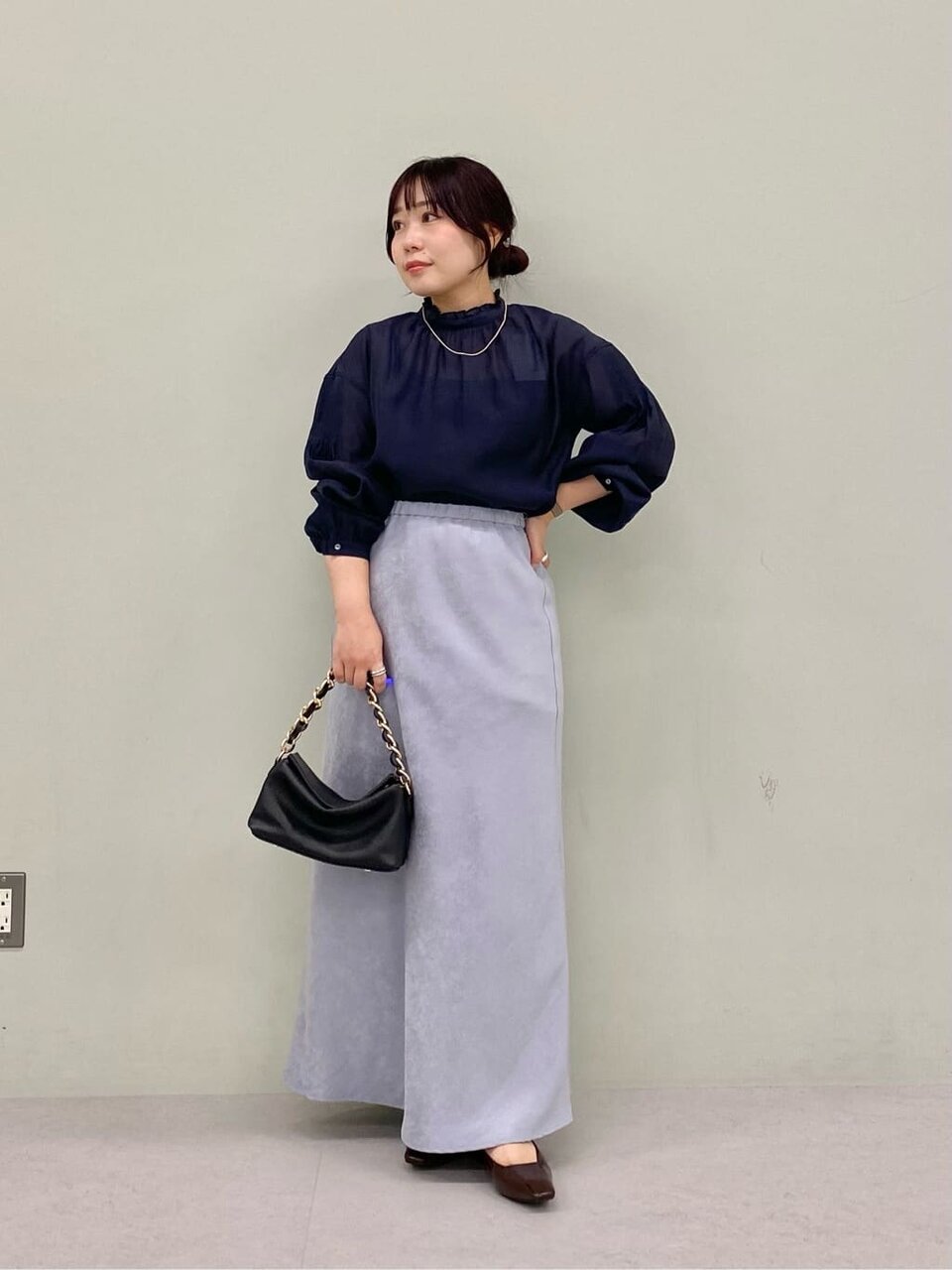 フリルブラウスとロングスカートを着た女性