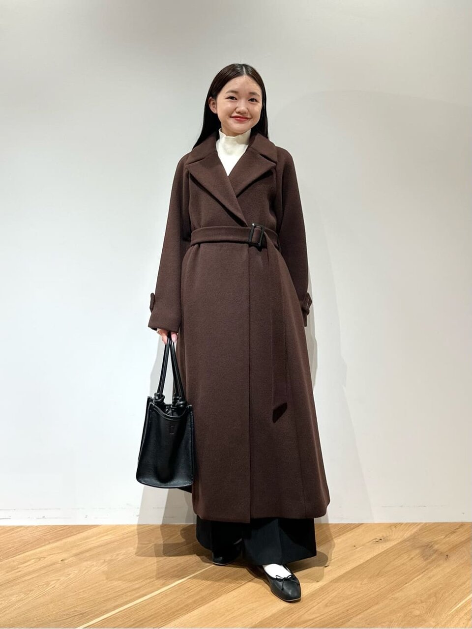 ロングコートとスラックスを着た女性
