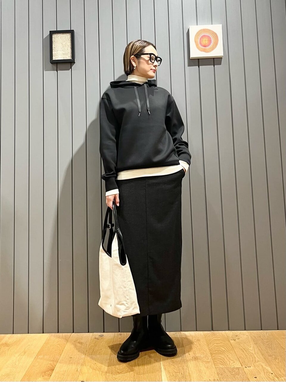 黒のフーディーとスカートを着た女性