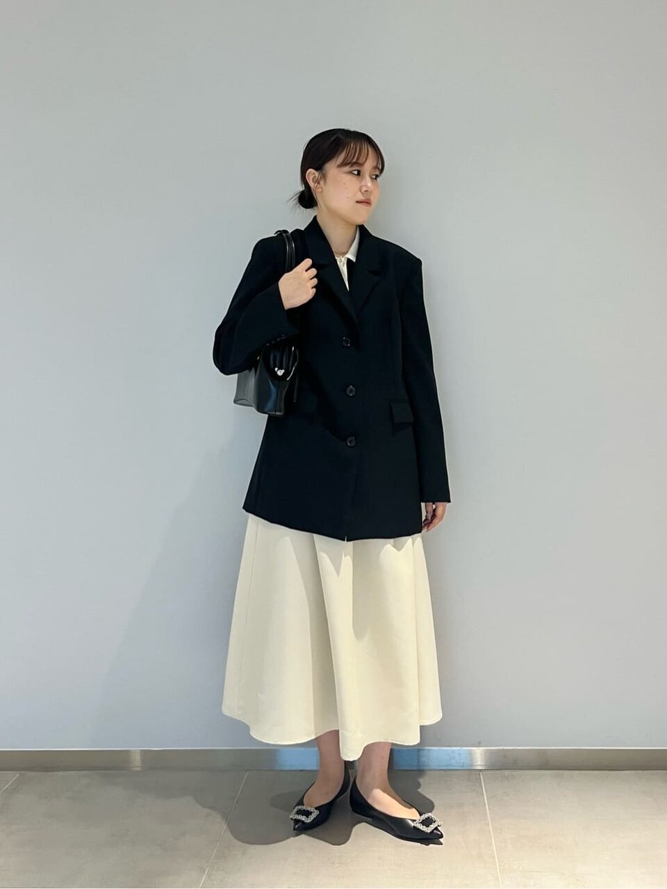 黒のジャケットとバイカラーワンピースを着た女性