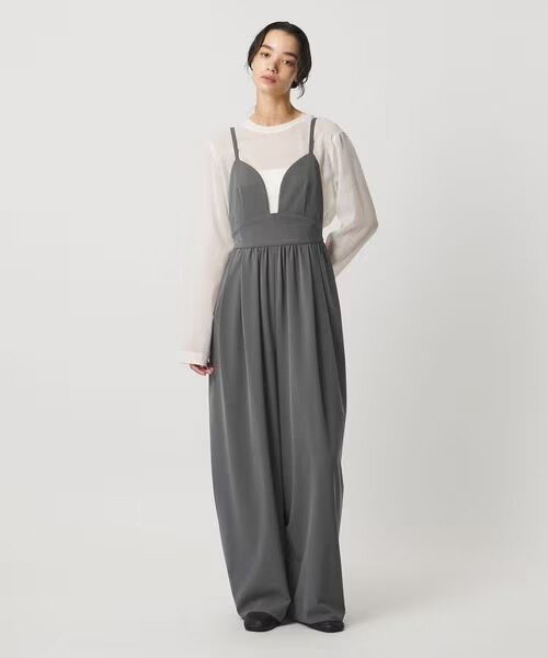 グレーのサロペットを着た女性