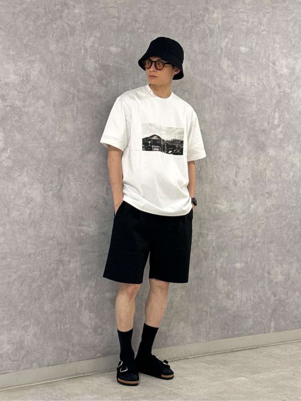 グラフィックTシャツとショーツを着た男性