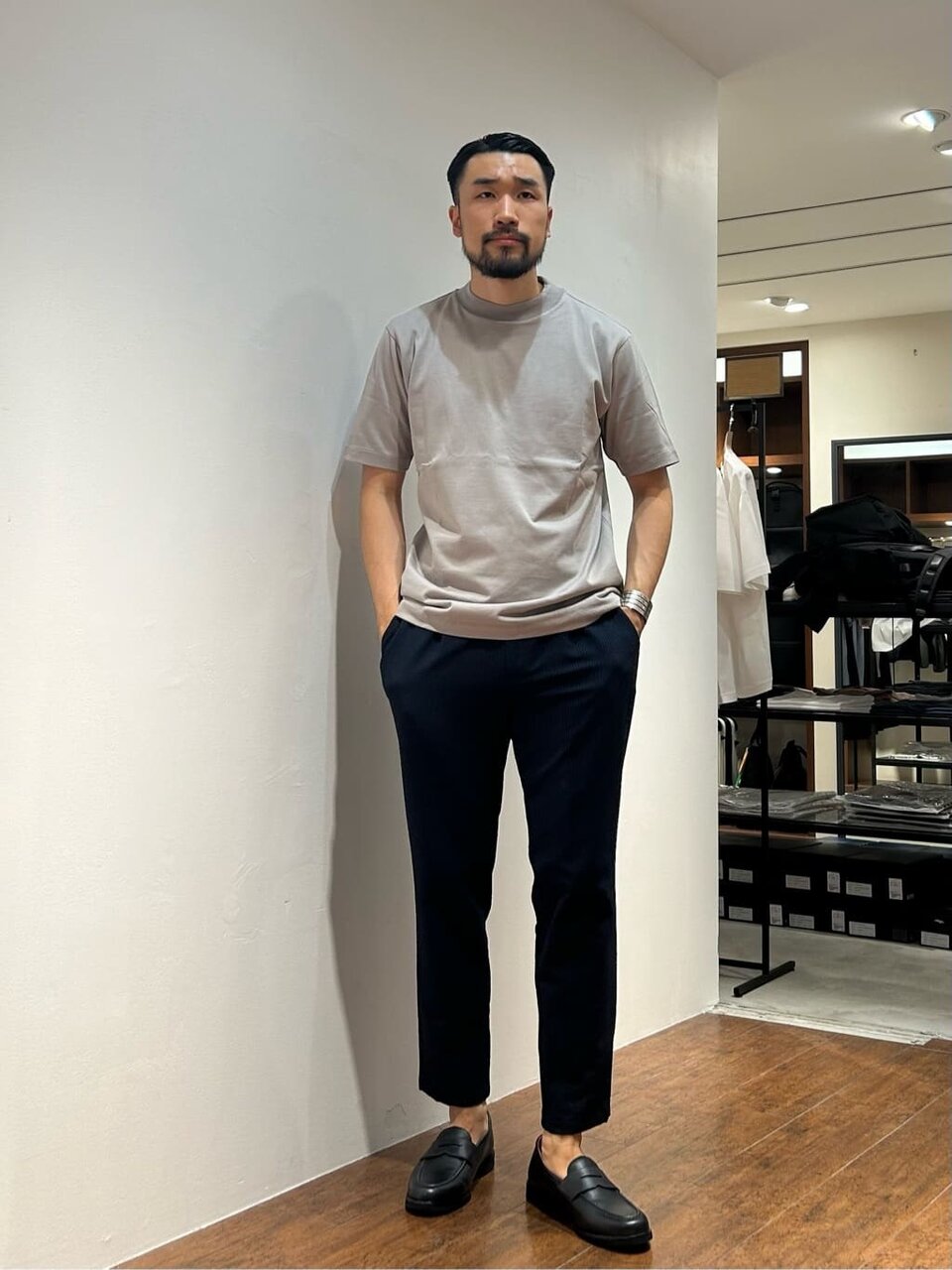 グレーTシャツにスラックスを着た男性