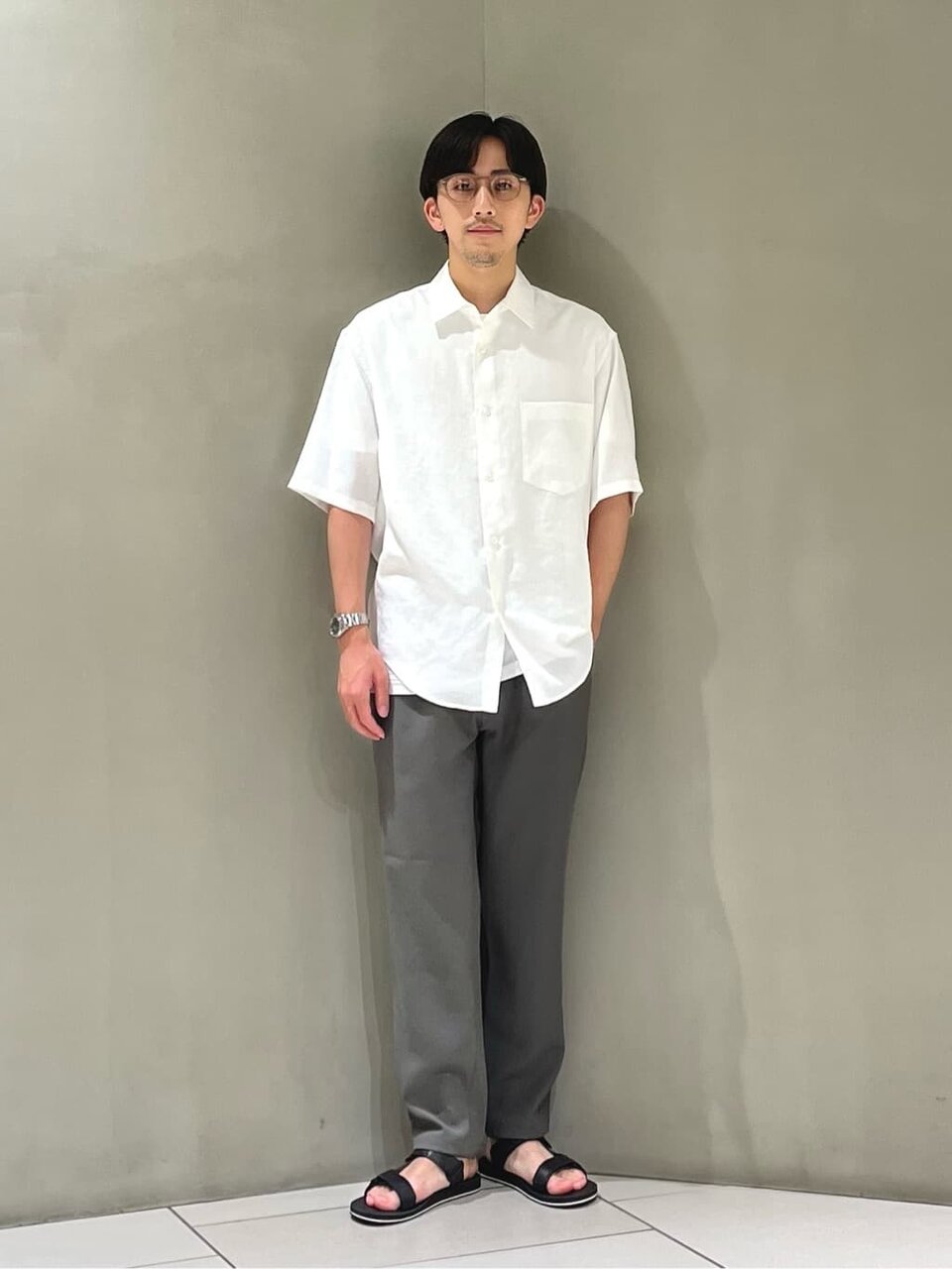 グレーTシャツにスラックスを着た男性
