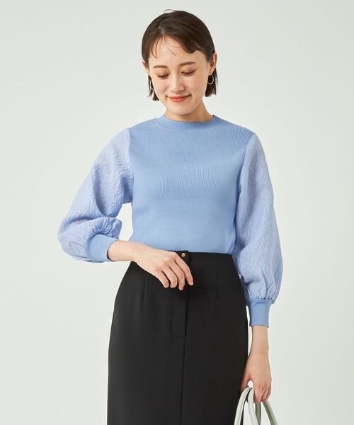 サックスブルーのニットを着た女性