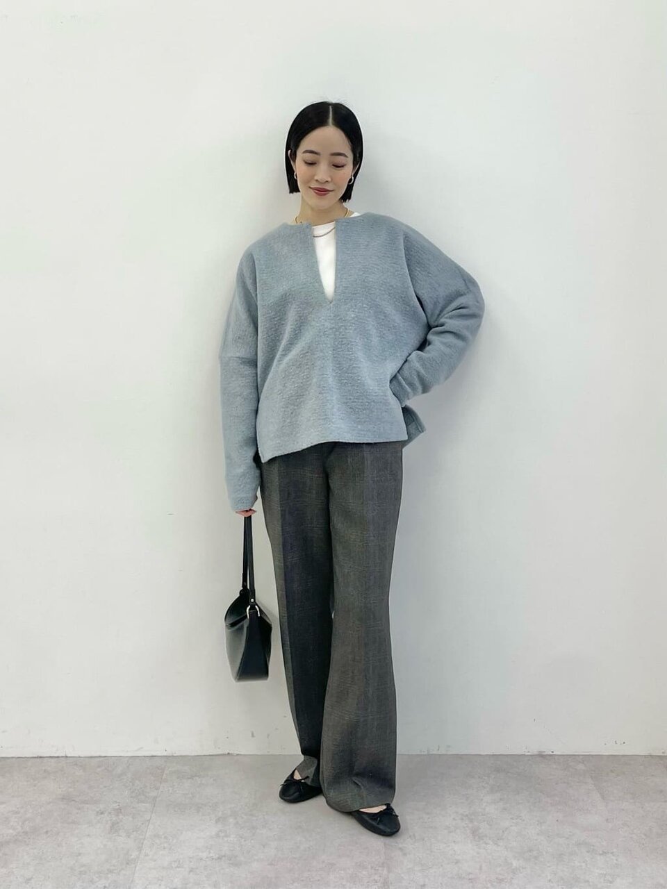 サックスブルーのシャツカーディガンを着た女性