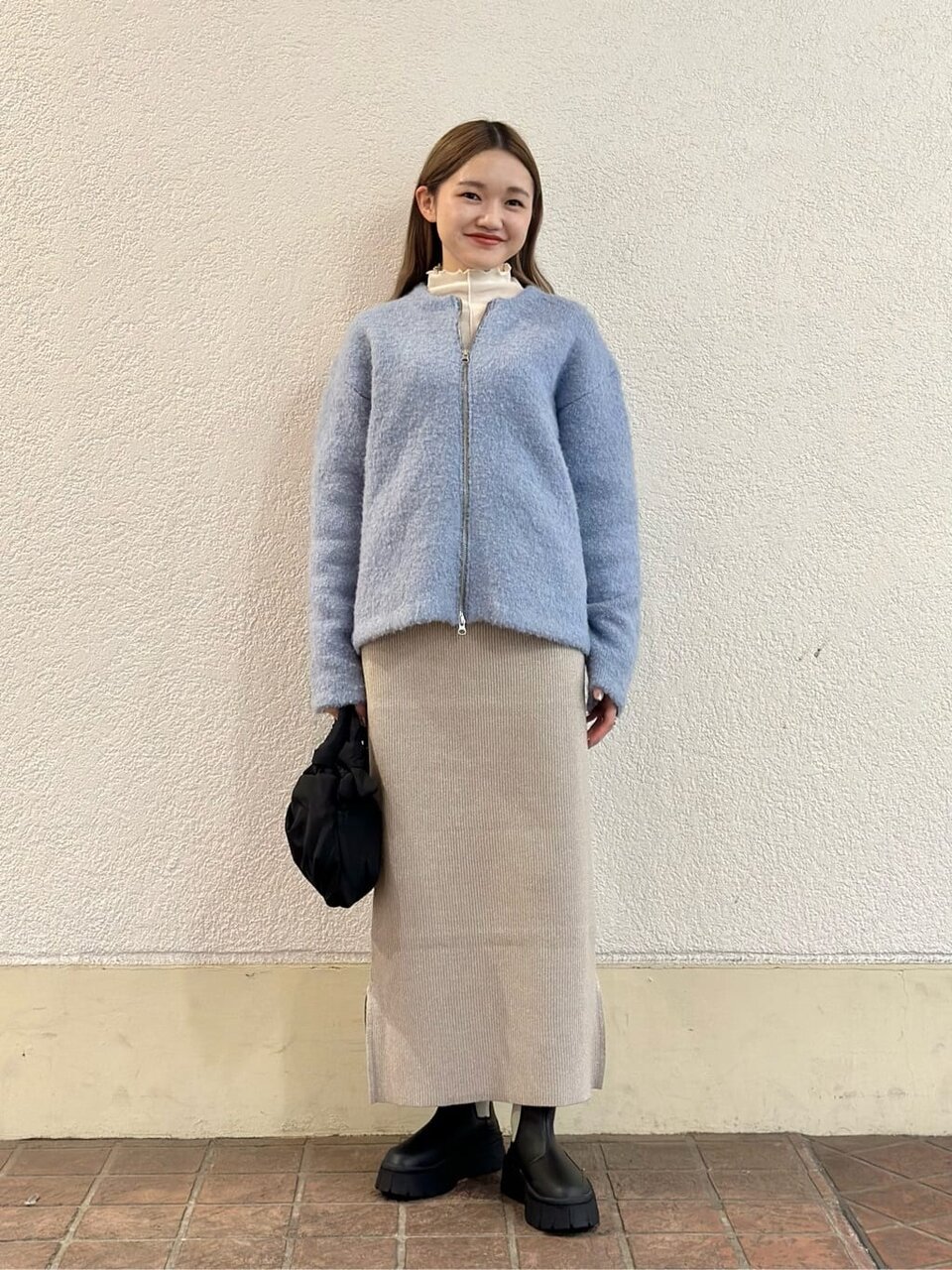サックスブルーのニットを着た女性