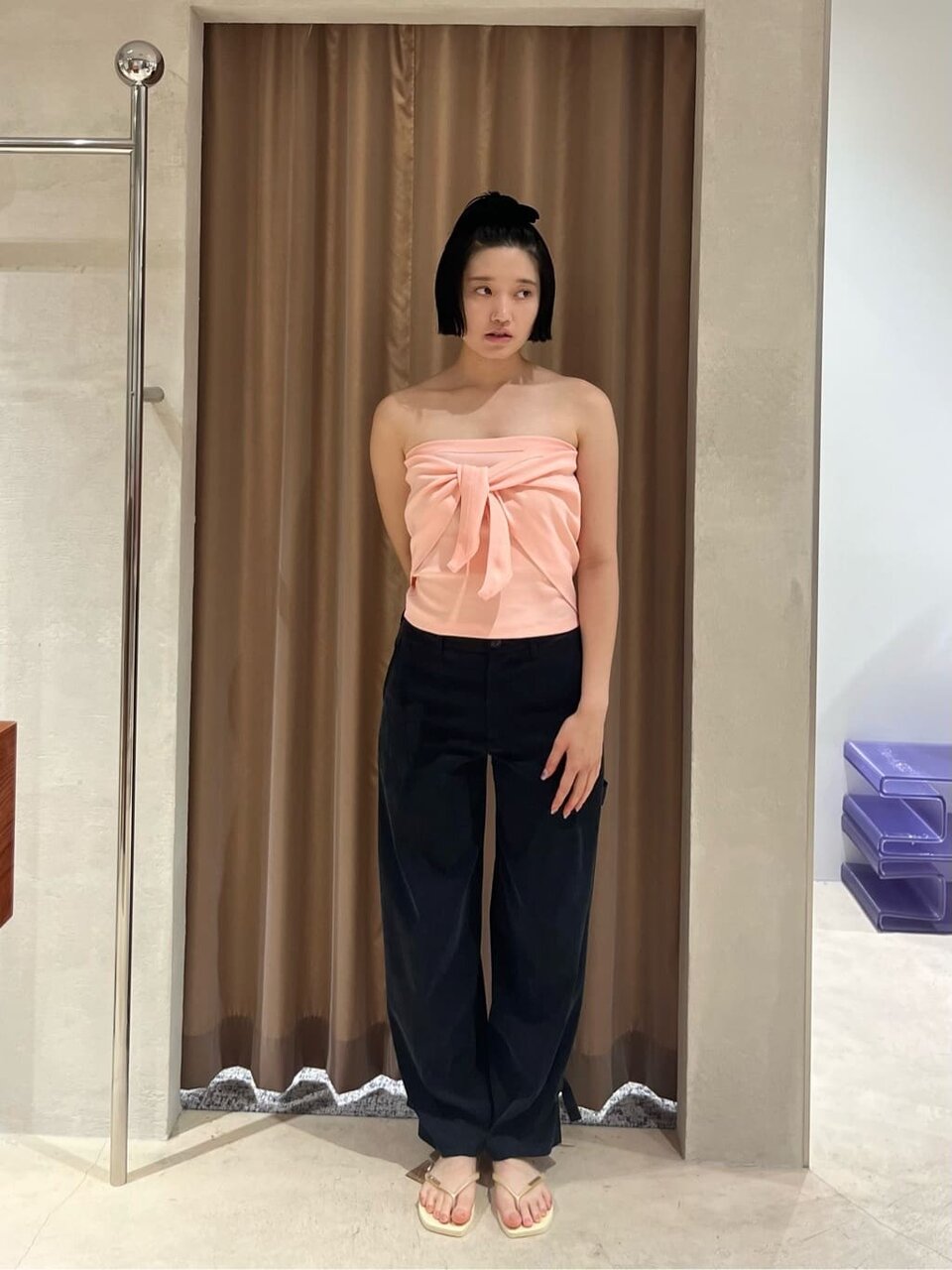 スカーフのトップスとサテンパンツを着た女性
